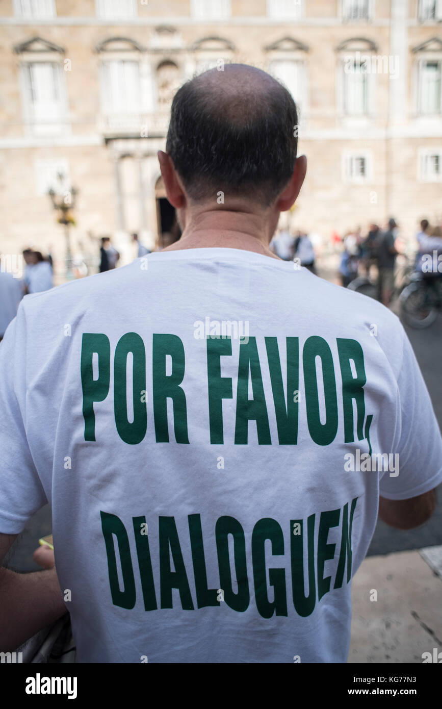 Un uomo con la frase "La preghiamo di parlare" in Plaça Sant Jaume, dove migliaia di persone chiedono ai governi di Catalogna e Spagna al dialogo. Credito: ca Foto Stock