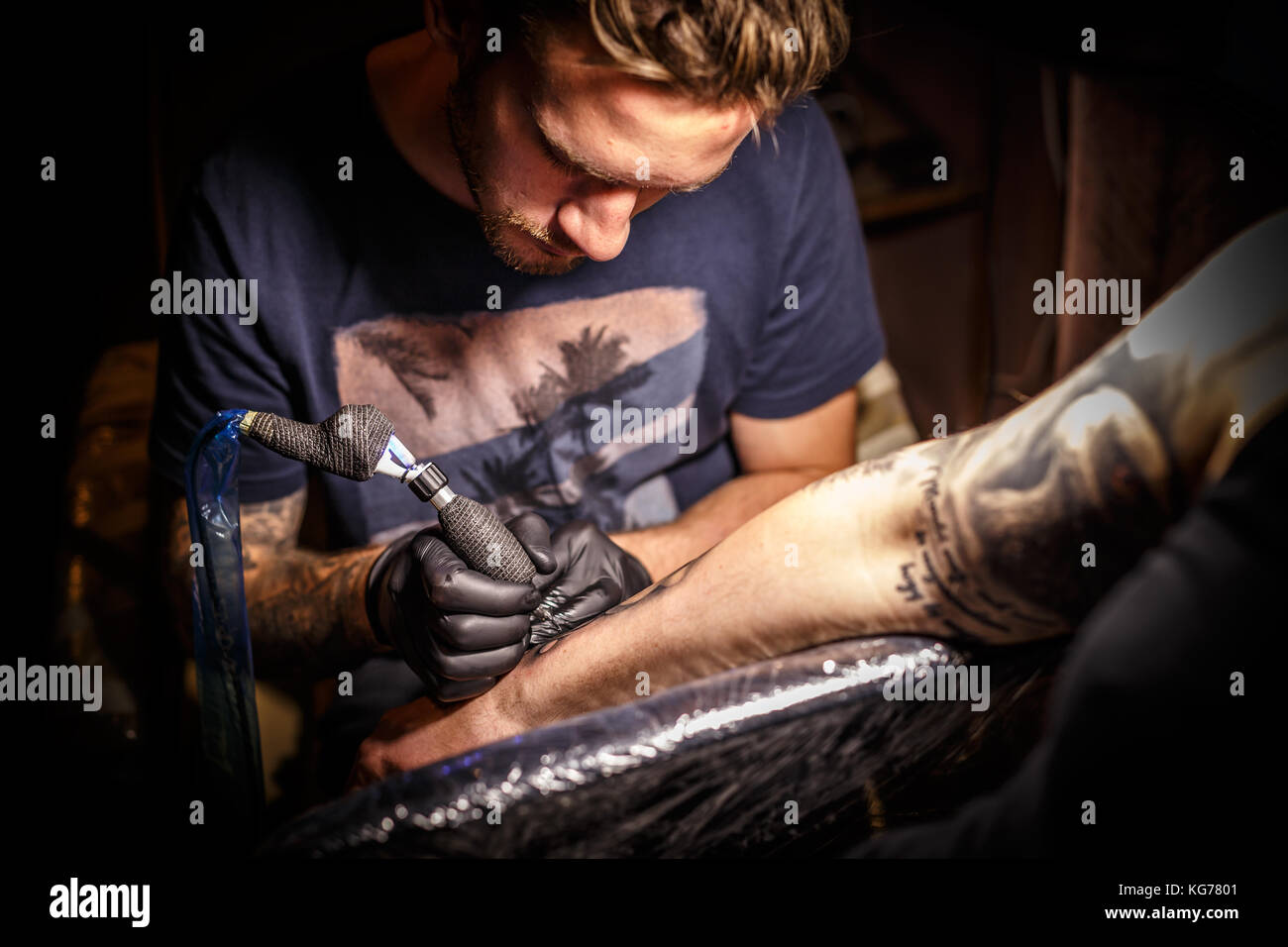 Professional tattoo artist in opera in un tattoo studio. Foto Stock