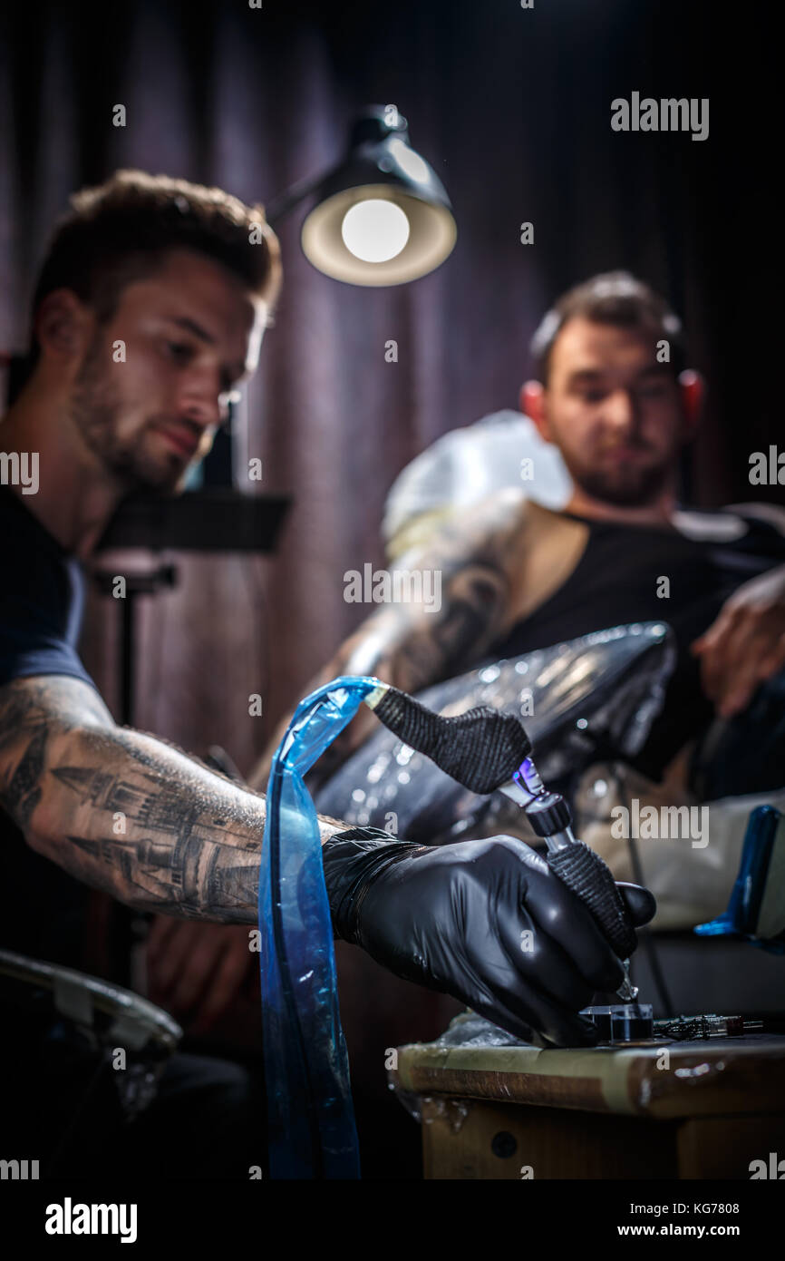 Master tattoo artist prepara gli strumenti per tatuaggio Foto Stock