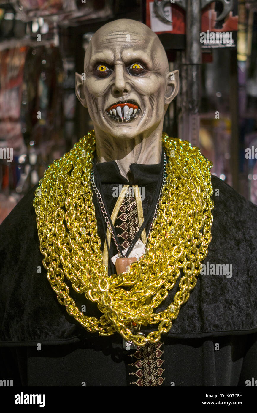 Un manichino con una maschera di spaventoso, cape e pesante catena in oro sul display in un costume store nel Greenwich Village di New York City. Foto Stock