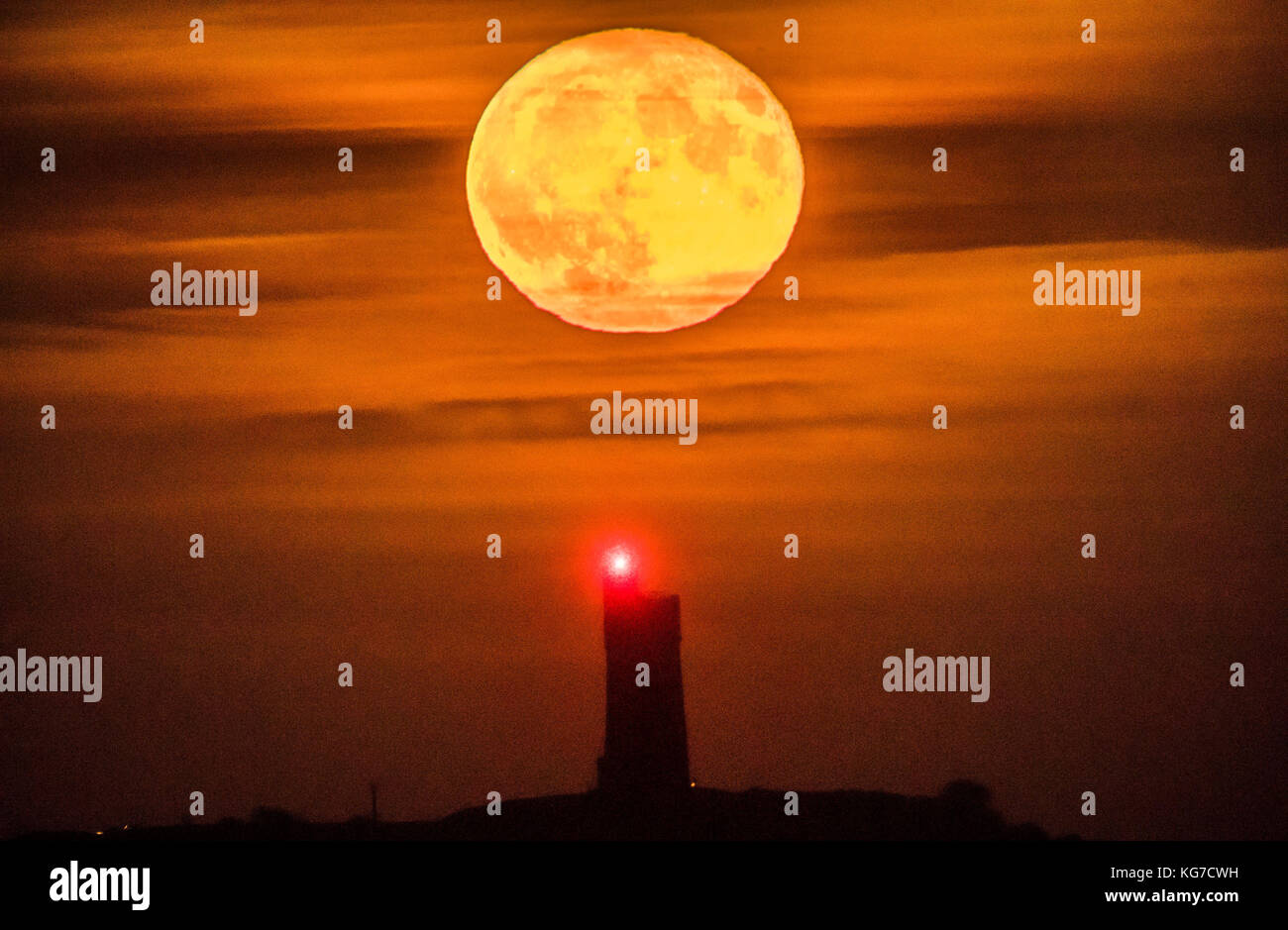 Una luna piena di novembre, che è conosciuta come una Luna di castoro o di Cacciatori secondo i nativi nordamericani, sorge dietro la Torre Victoria di grado II, elencata sulla cima della collina del castello in Huddersfield. Foto Stock