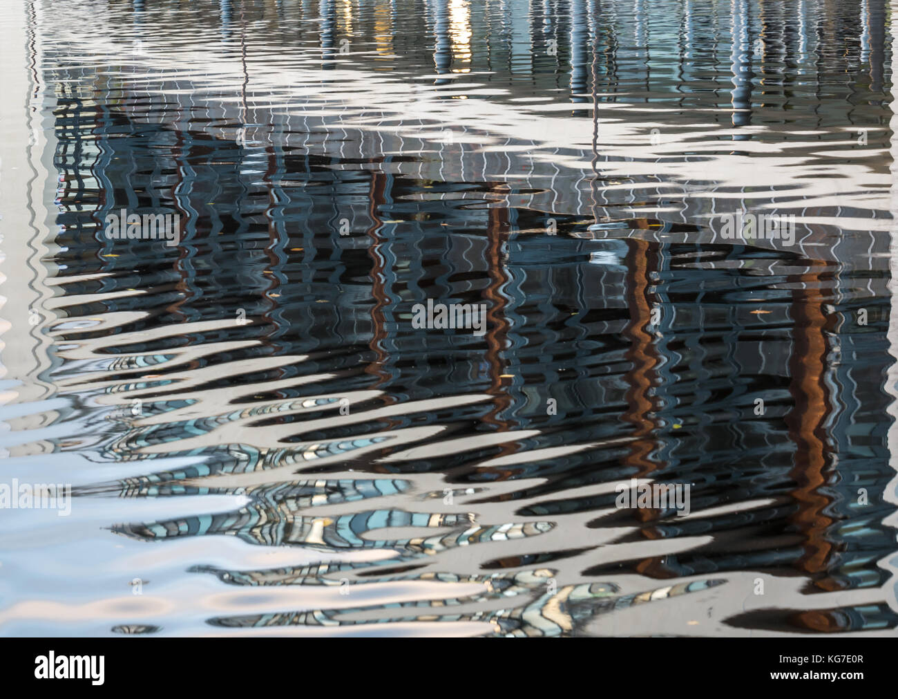 Riflessioni del moderno blocco di appartamenti in acqua calma delle acque del fiume di Leith, creando ondulata pattern astratti, Edimburgo, Scozia, Regno Unito Foto Stock