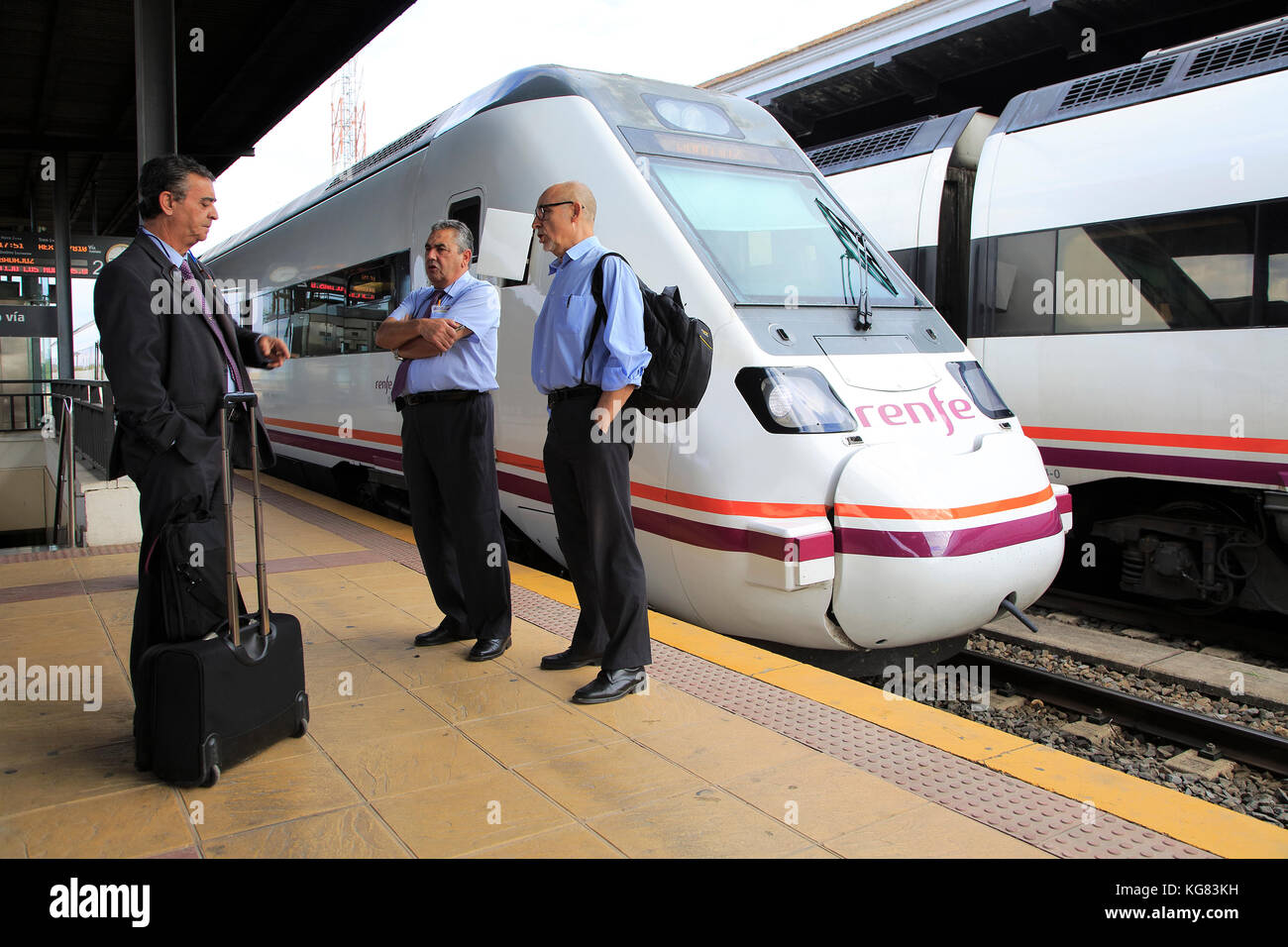 Treno RENFE a piattaforma della stazione ferroviaria con il personale del treno, Merida, Estremadura, Spagna Foto Stock