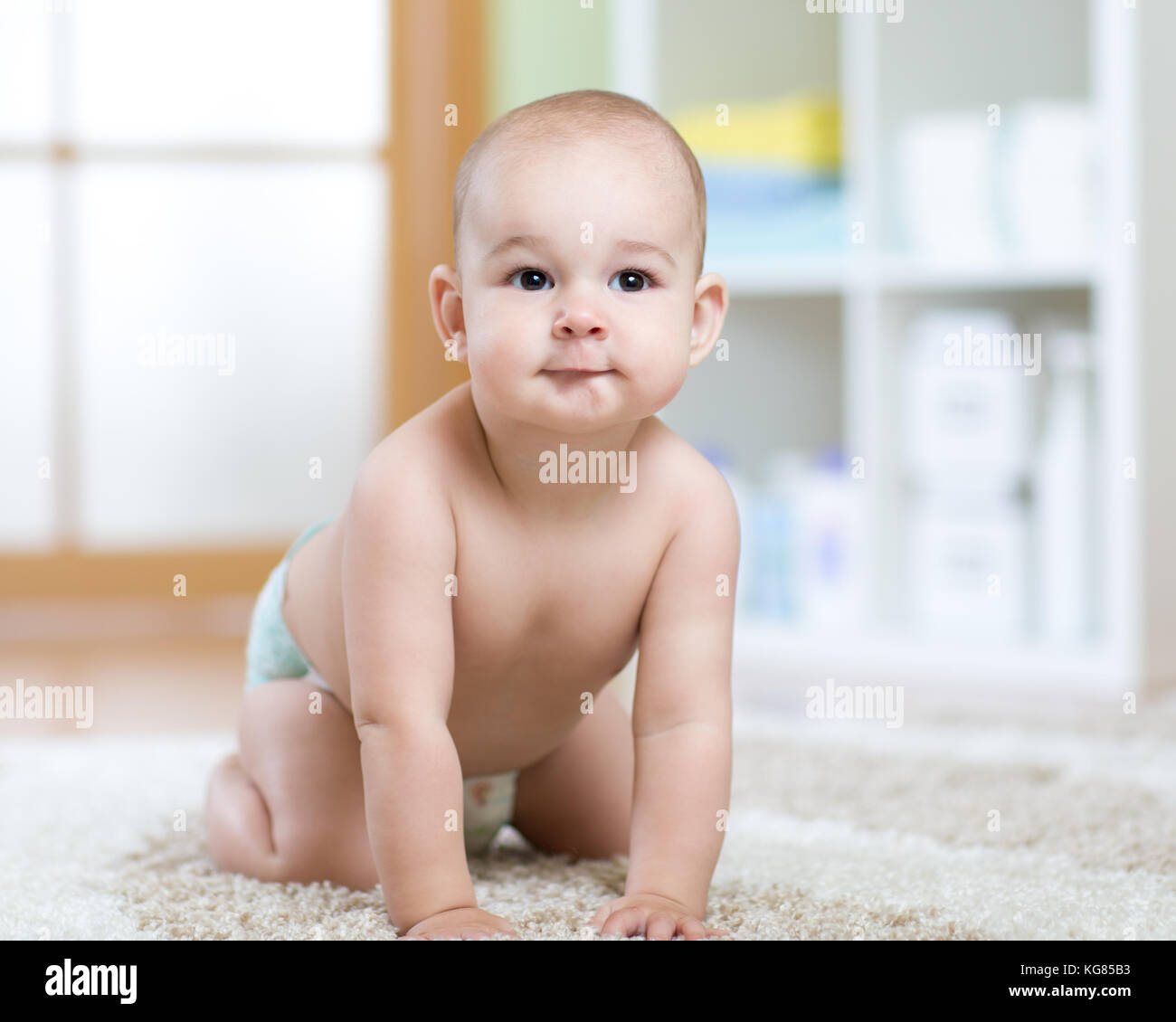 Happy baby strisciando sul tappeto a casa Foto Stock