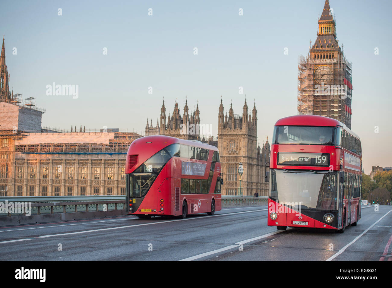 Westminster Bridge, Londra, Regno Unito. 5 novembre 2017. Due autobus New Routemaster attraversano il ponte di Westminster in direzioni opposte con la torre dell'orologio coperta che ospita il Big ben sullo sfondo. Credit: Malcolm Park/Alamy Live News. Foto Stock