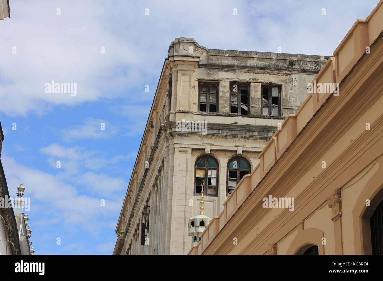 Guardando il vecchio edificio con facciata danneggiata e finestre rotte, Avana, Cuba. Foto Stock