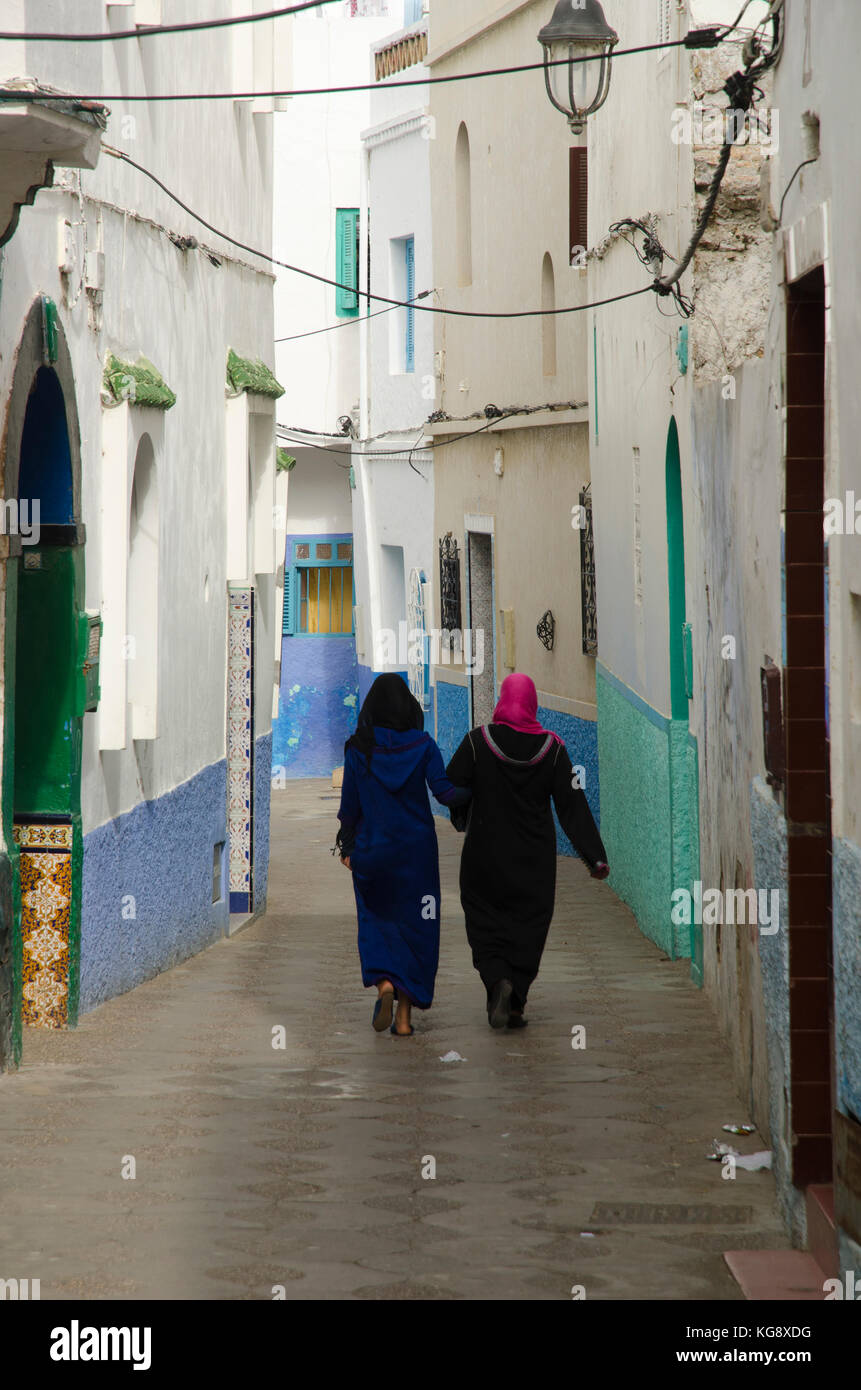 Donne locali a piedi attraverso medina, Asilah, nord del Marocco Foto Stock