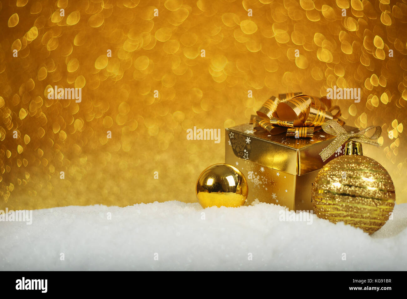 Golden decorazioni di Natale nella neve su sfondo glitter Foto Stock