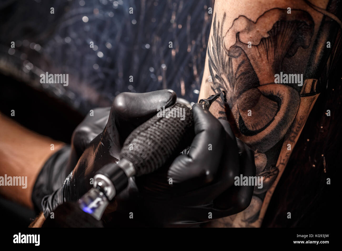Uomo adulto che lavora con il braccio della penna per tatuaggi Foto stock -  Alamy