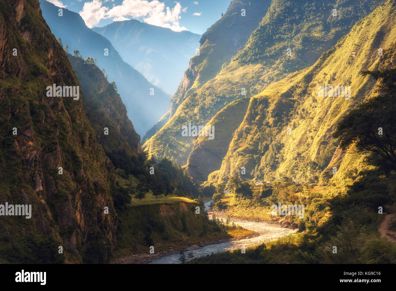 Un paesaggio fantastico con alta montagna himalayana, bellissimo fiume di curvatura, foresta verde, cielo blu con nuvole e sole giallo in autunno in Nepal. m Foto Stock