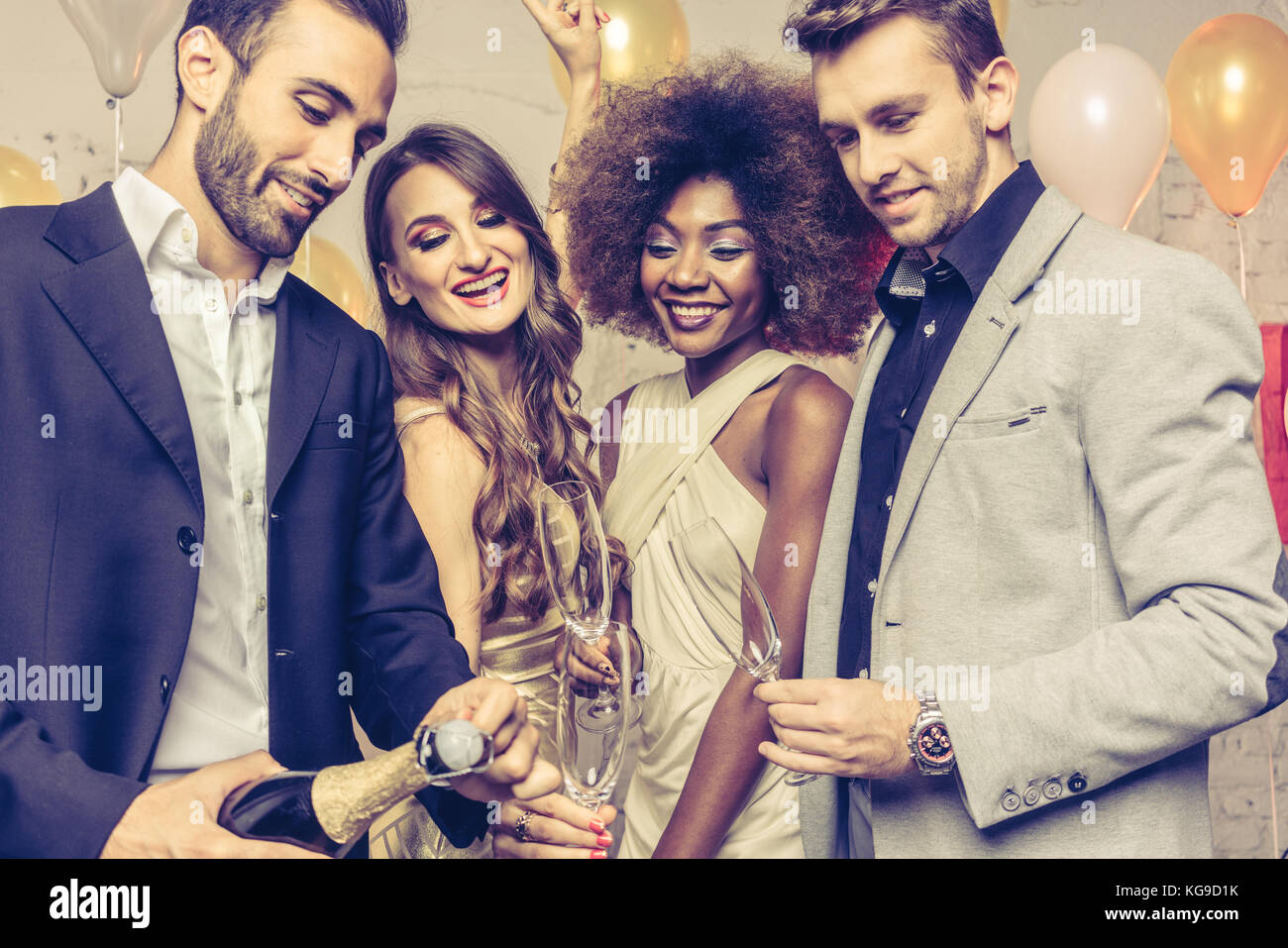 Uomo di apertura della bottiglia di champagne sulla celebrazione nel club Foto Stock