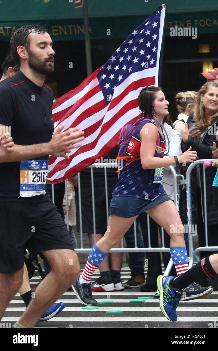 La città di New York, New York, Stati Uniti d'America. 5 Novembre, 2017. Una donna che tiene una bandiera americana come lei corre fino 1° Avenue a Manhattan durante la maratona di New York. Credito: Nancy Kaszerman/ZUMA filo/Alamy Live News Foto Stock