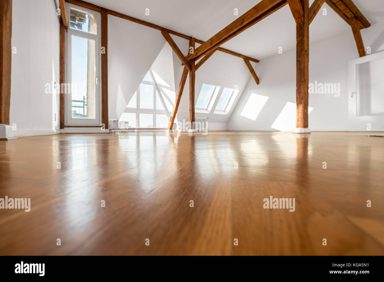 Stanza vuota con pavimento in legno e travi del tetto - mansarda Foto Stock