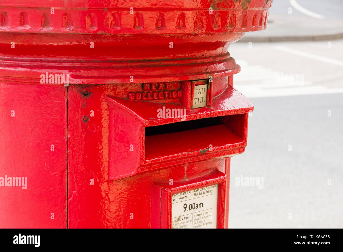 Stile classico Britannico rosso post box in Llangollen Galles del Nord con bilingue gallese e inglese orari di raccolta Foto Stock
