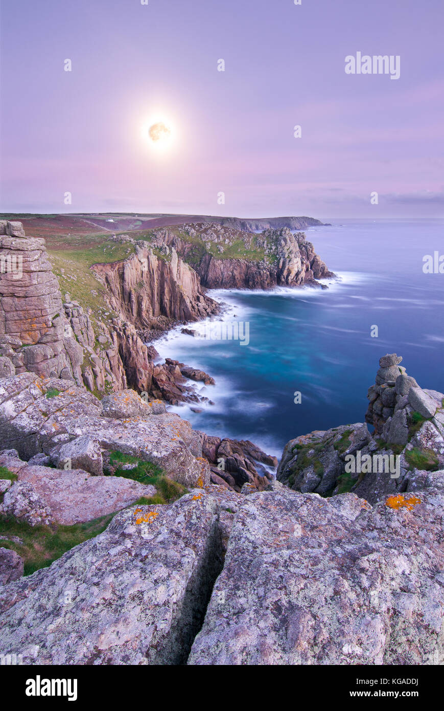 Un incredibile la luna piena sorge sopra il punto pordenack vicino Land's End nell'angolo sud-occidentale di cornwall, Regno Unito. Foto Stock