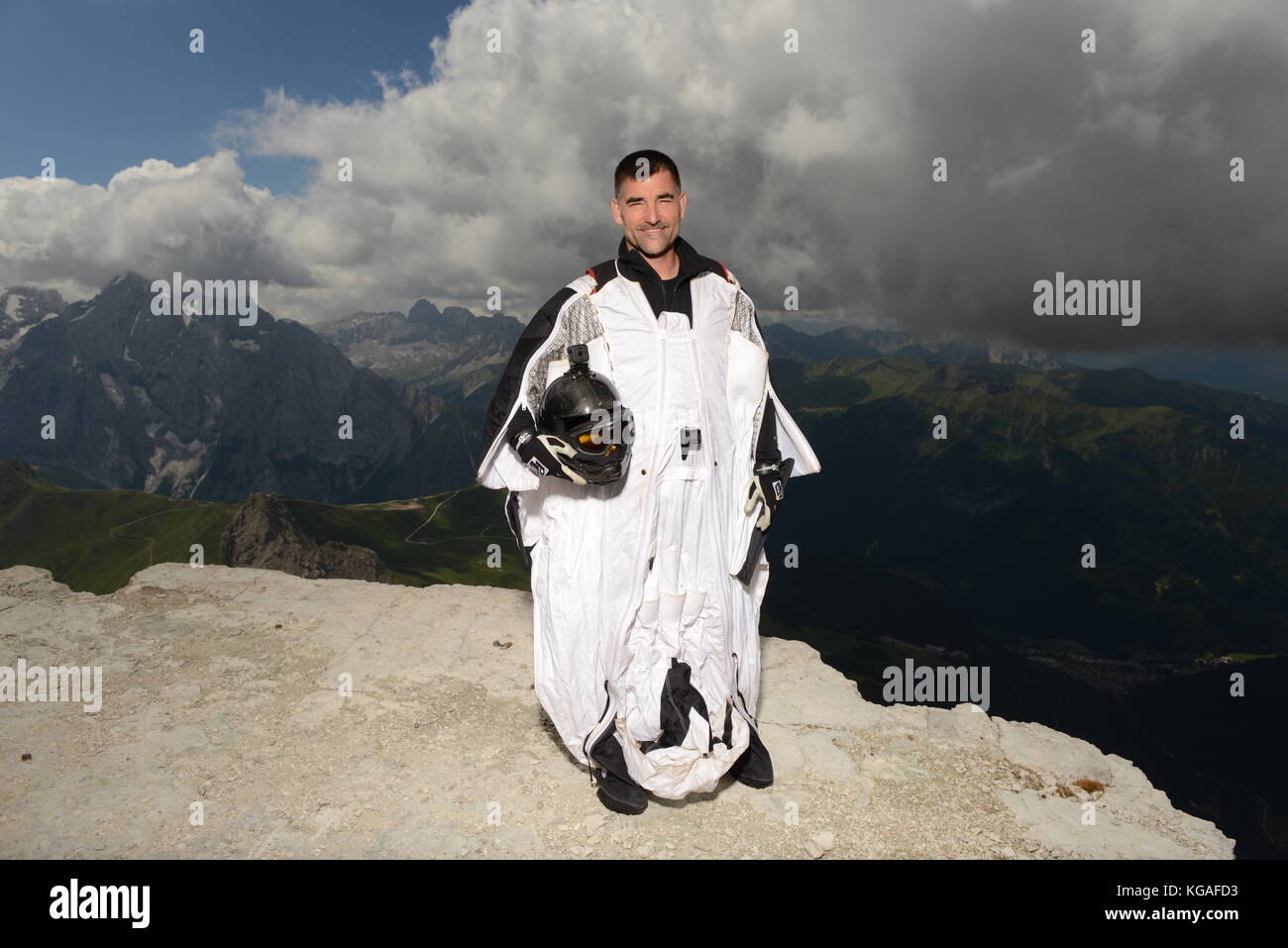 Wingsuit ponticello di base è il pensiero circa il suo passo successivo per passare dalla scogliera dietro di lui. La concentrazione è alta per la successiva fase di lancio verso il basso. Foto Stock