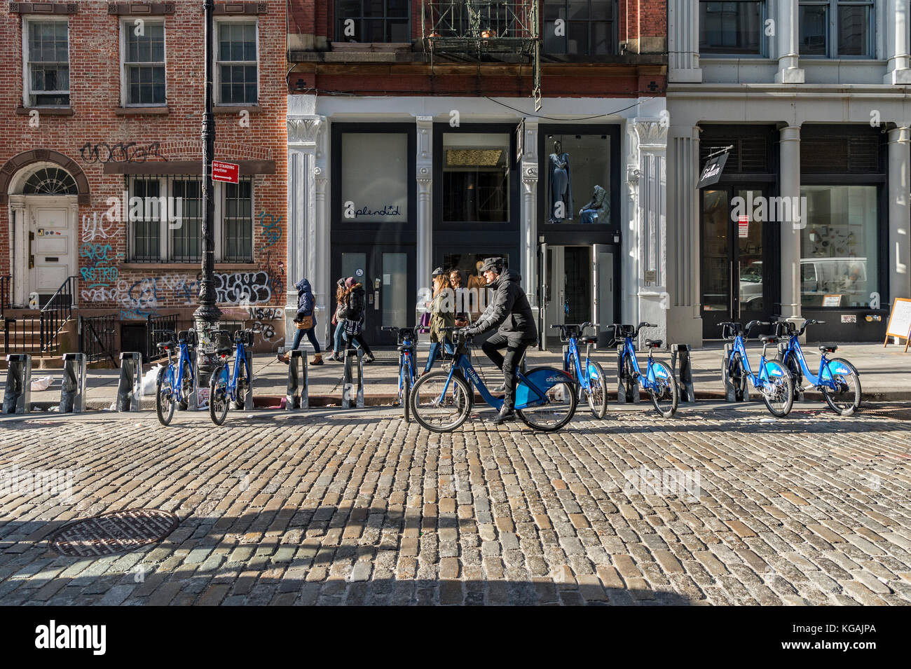 Un ciclista corse citibike passato un parcheggio citibike stand a new york. Foto Stock