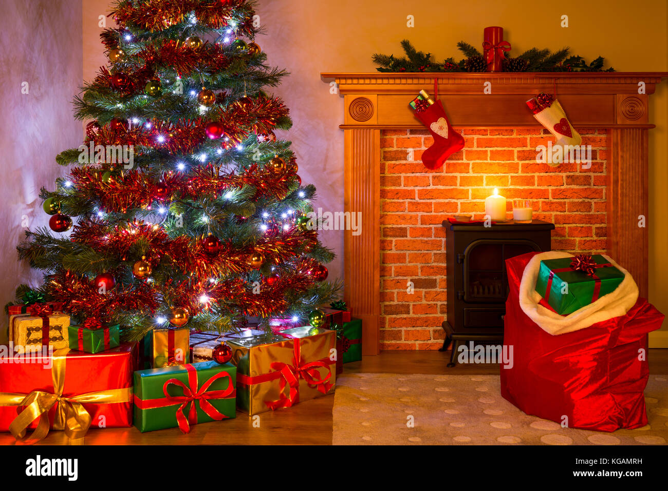 Un soggiorno alla vigilia di Natale con presenta sotto l'albero, un pasticcio di carne macinata e bicchiere di latte sul camino in attesa di santa. Foto Stock