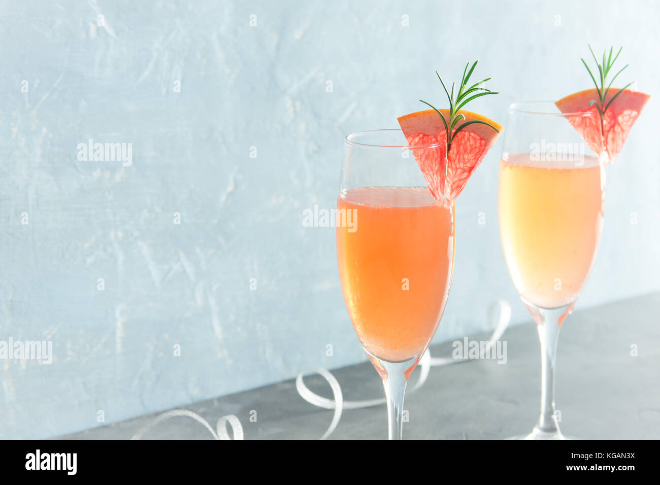 Mimosa drink festiva - champagne cocktail mimosa con succo di pompelmo e rosmarino per party, spazio di copia Foto Stock