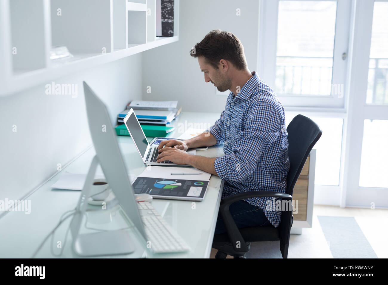Uomo attento utilizzando laptop alla scrivania Foto Stock