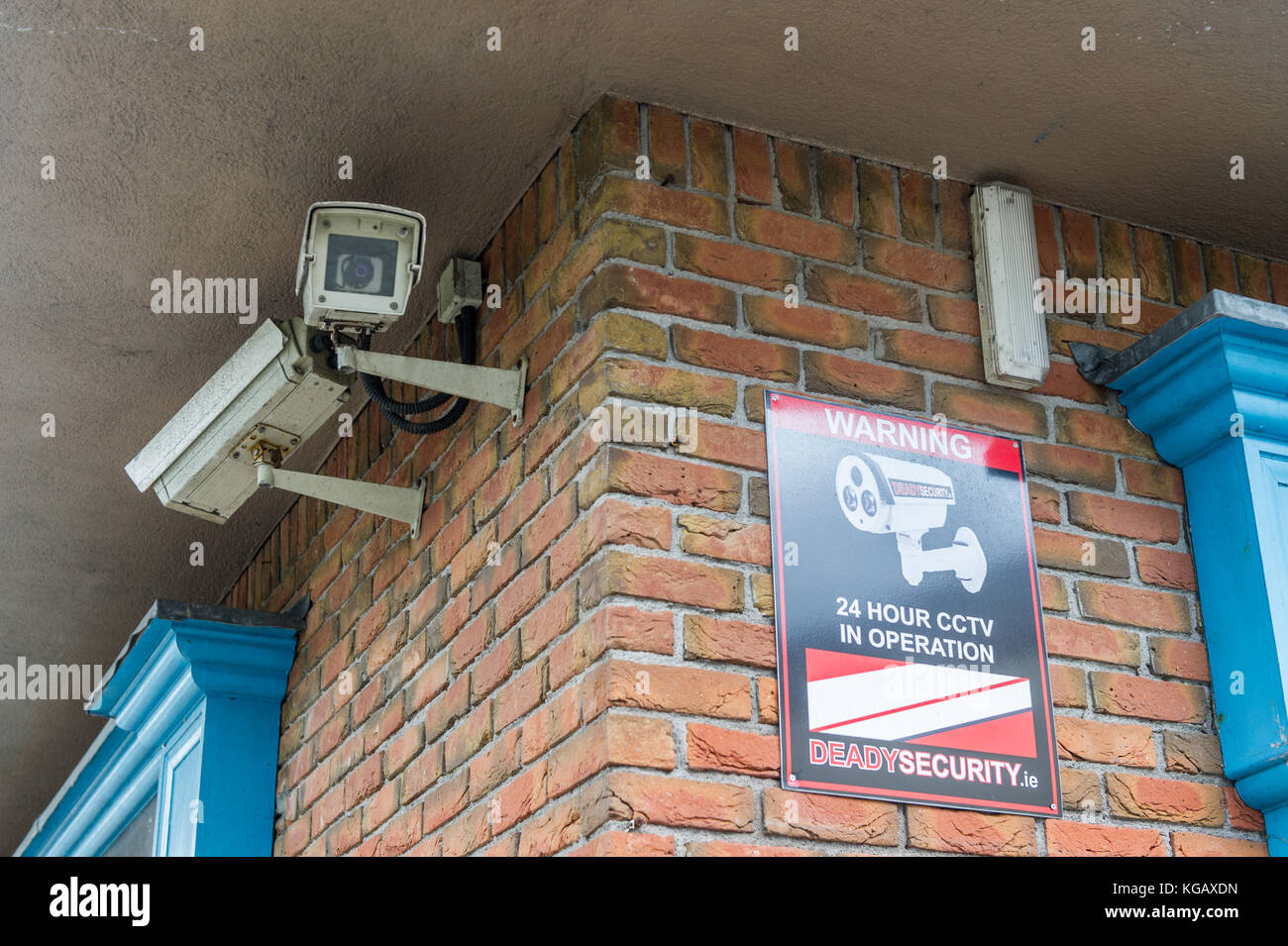 Due telecamere TVCC su un muro di mattoni rivolti in direzioni opposte. Foto Stock