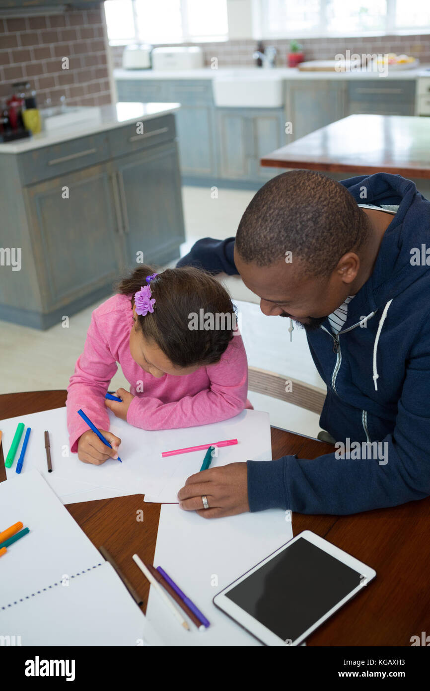 Padre aiuta a sua figlia con la sua scuola compiti a casa Foto Stock
