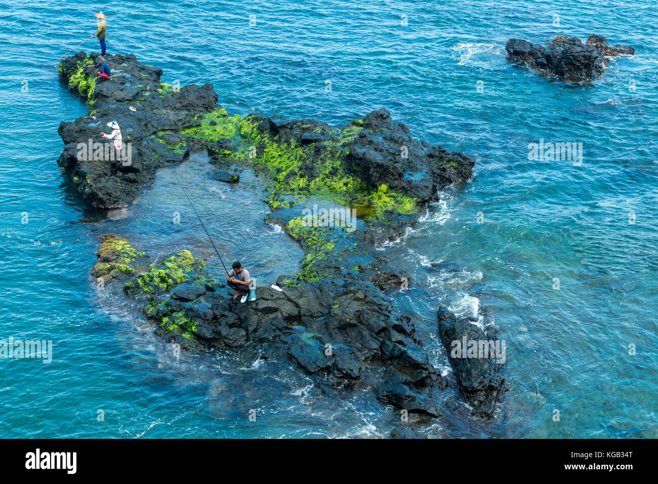 Senggigi - pescatori su roccia appena offshore Foto Stock