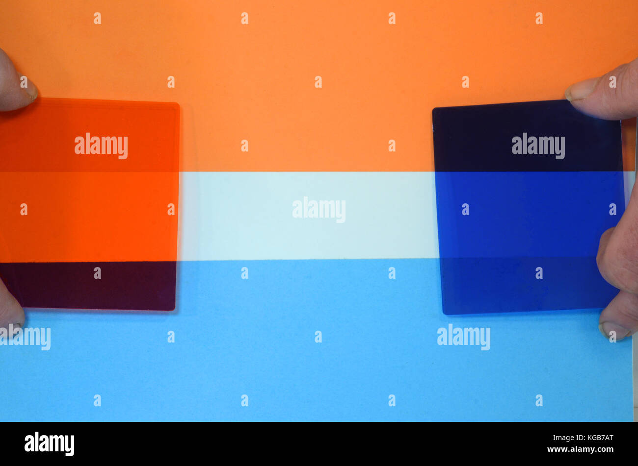 I filtri di colore tenuto contro un foglio di carta con due colori complementari. Come si può vedere ogni filtro filtri di colore opposto a diventare piuttosto buia. Foto Stock