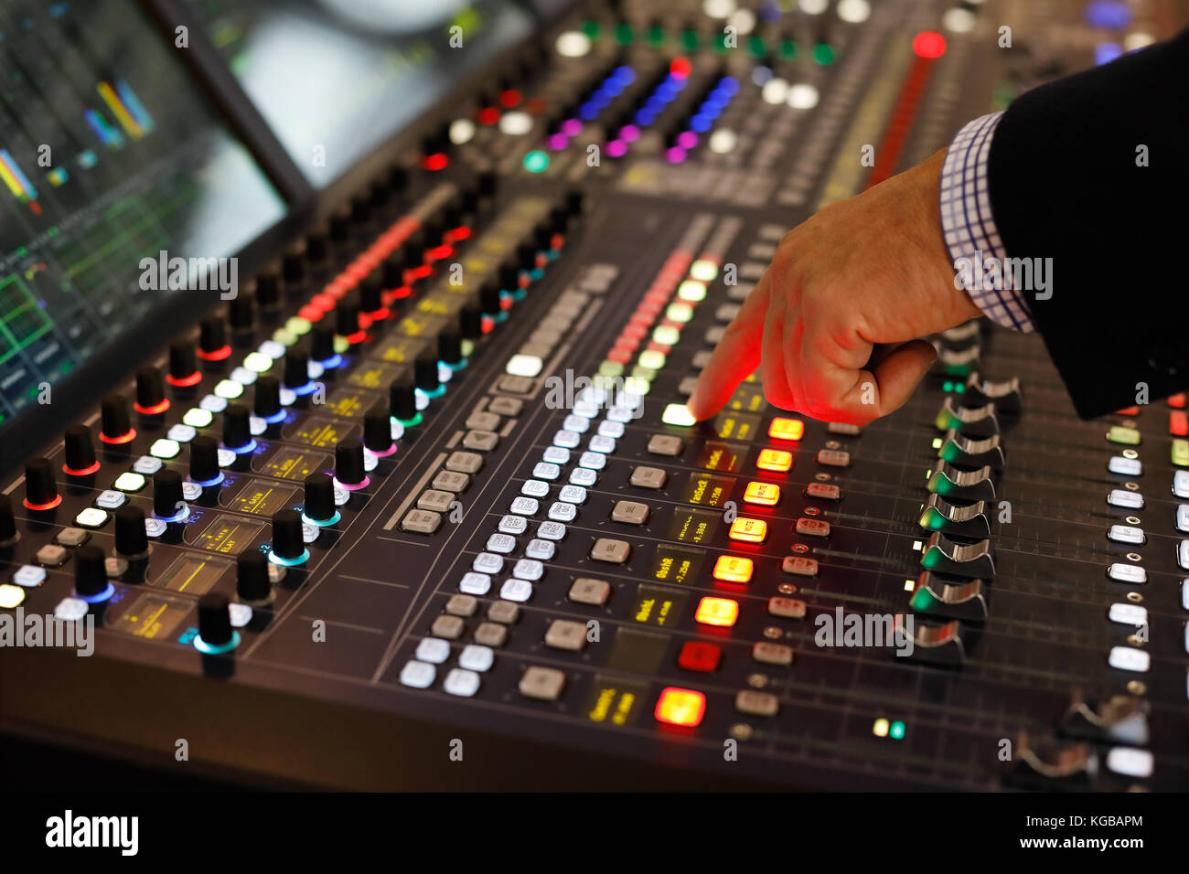 Un tecnico del suono ai comandi di una console di produzione audio. Messa a fuoco selettiva. Foto Stock