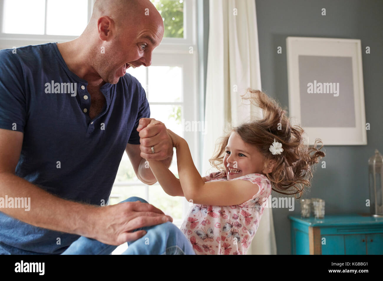 Padre e figlia divertirsi saltando insieme a casa Foto Stock