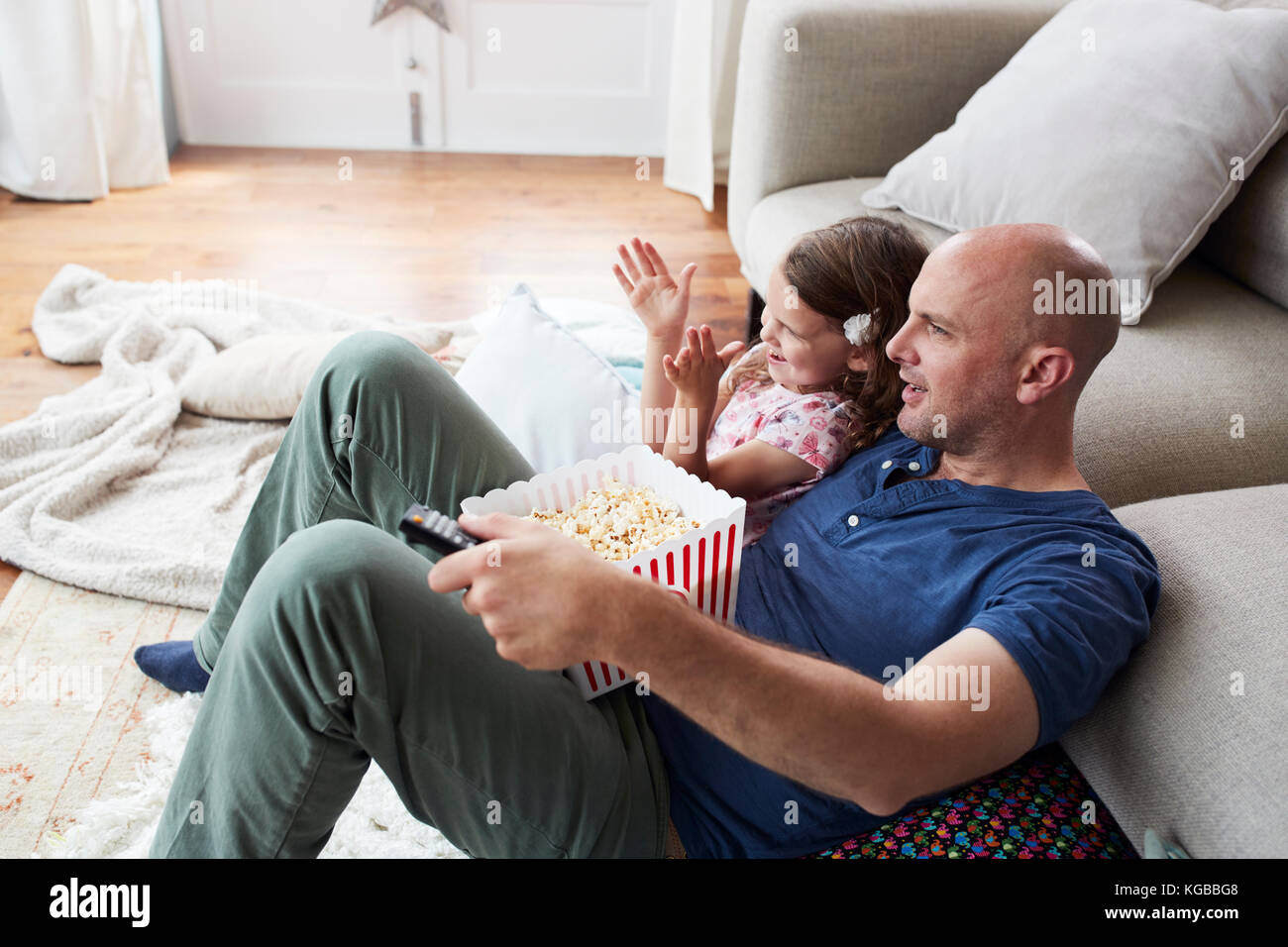 Padre e figlia la visione di un filmato con popcorn a casa Foto Stock