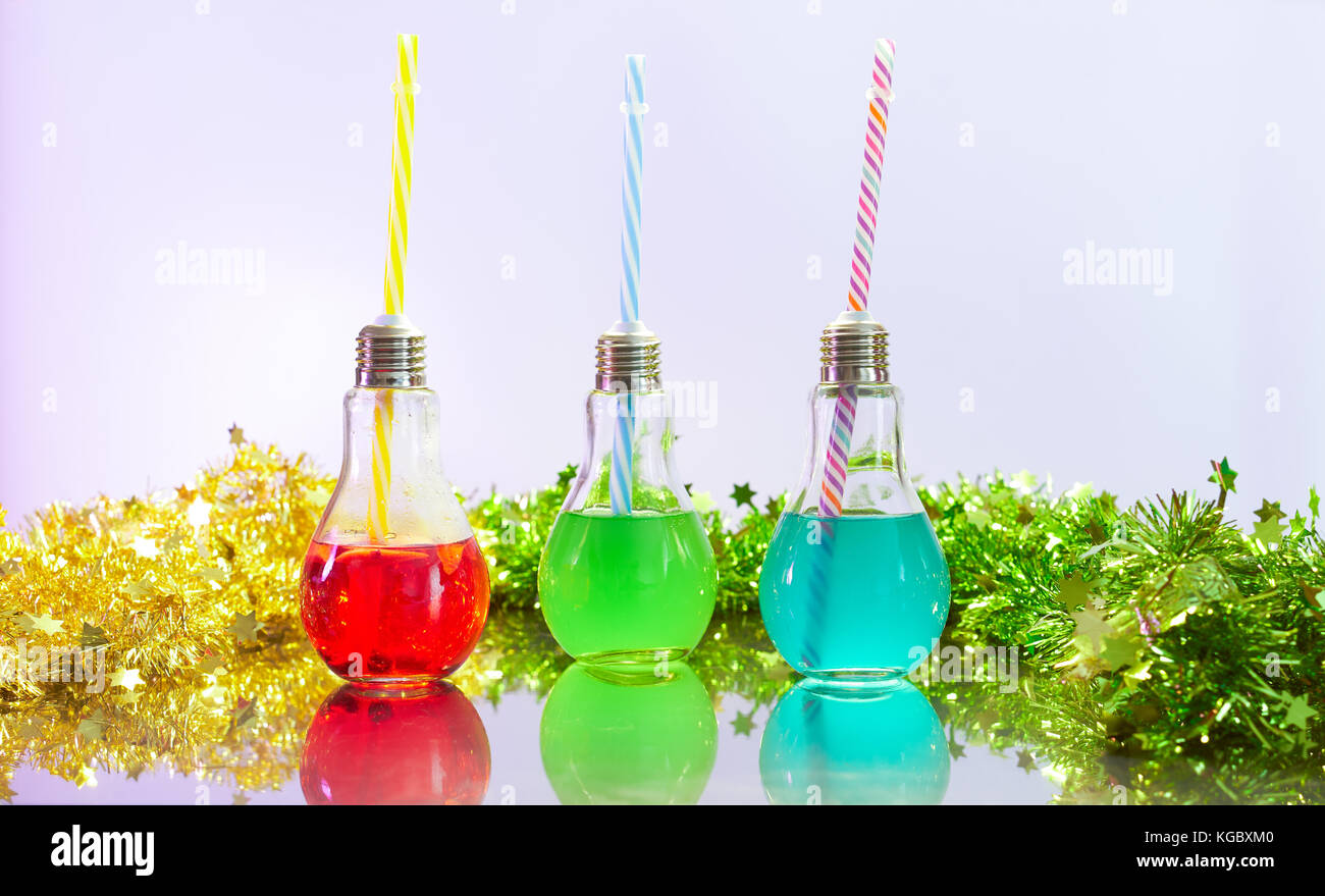 Tre cocktail colorati per party in luce a forma di bulbo bicchieri. copia spazio. Foto Stock