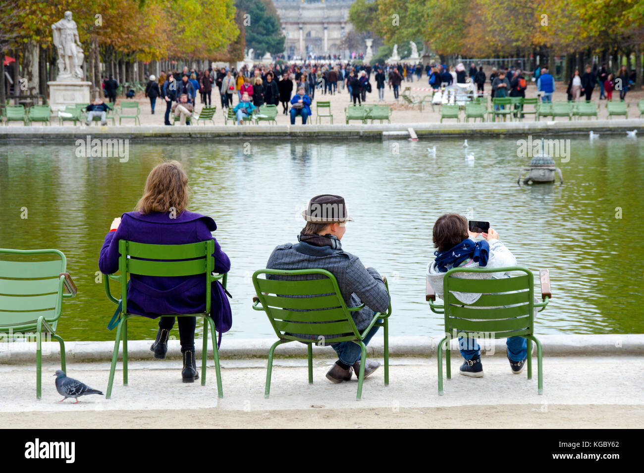 Parigi, Francia. Jardin des Tuileries. Autunno - persone che si siedono intorno al Bassin Ottagonal (stagno) Foto Stock