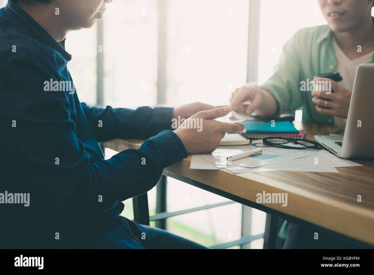 Giovani hipster lavoratore puntando al tablet pc schermo per presentare qualcosa al suo collega durante la riunione in uno spazio di lavoro. un brainstorming e il lavoro di squadra concetto Foto Stock