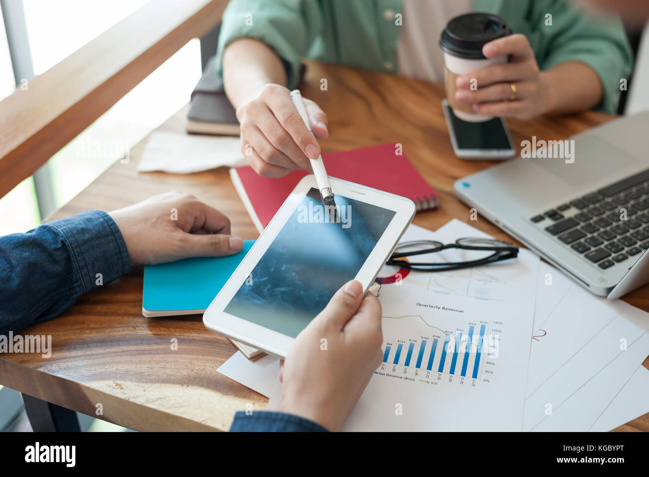 Giovani hipster lavoratore puntando al tablet pc schermo per presentare qualcosa al suo collega durante la riunione in uno spazio di lavoro. un brainstorming e il lavoro di squadra concetto Foto Stock