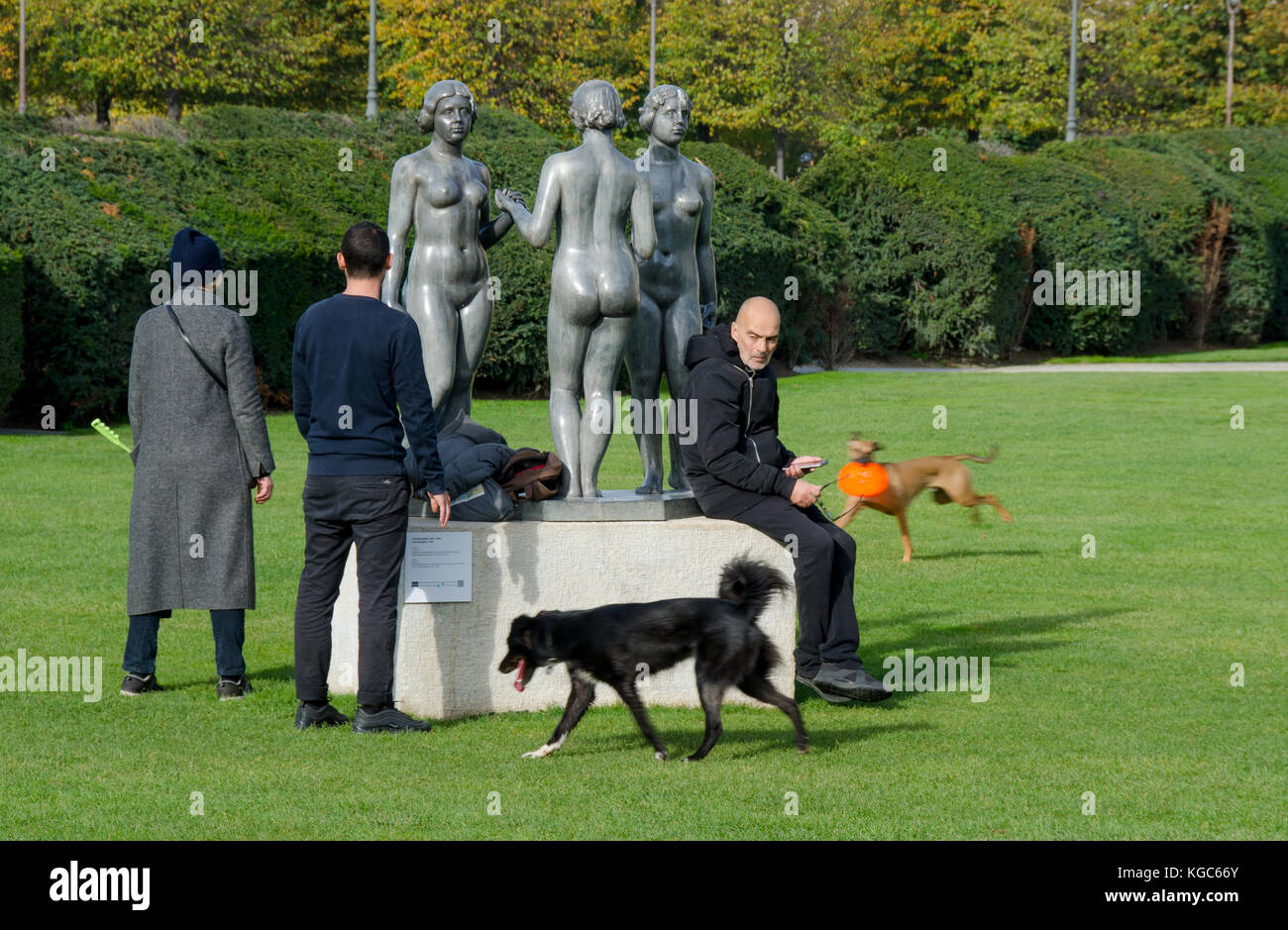 Parigi, Francia. Jardin des Tuileries: Les Nymphes / Trois Grâces (tre grazie) di Aristide Maillol, 1938. Uomo con telefono cellulare e cane escursionisti Foto Stock