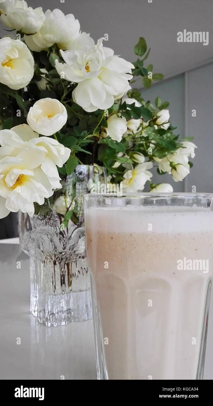 Self-made latte di mandorla sulla tabella unitamente a Midsummer rose Foto Stock