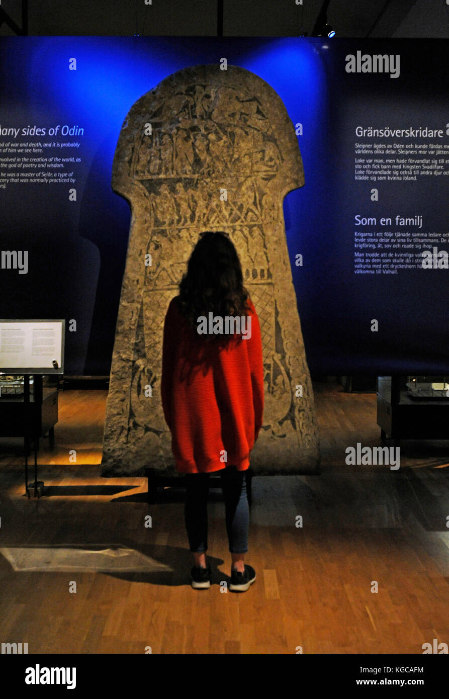Museo storico di Stoccolma Svezia. ragazza contemplando la pietra runica di tangelgarda. Viii secolo. età del ferro. Da larbro, isola di Gotland. Foto Stock