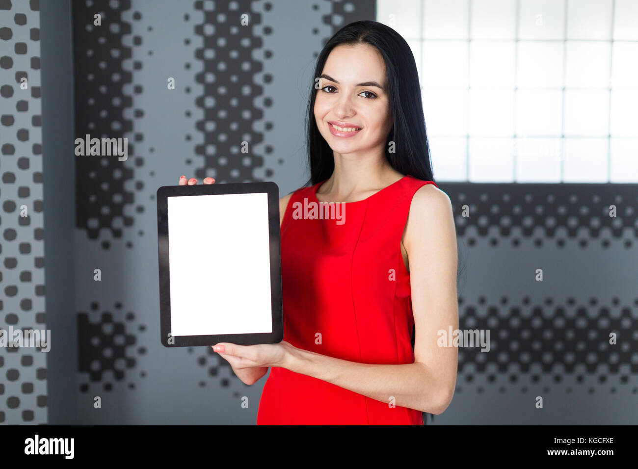 Attraente businesslady in abito rosso show vuoto tablet Foto Stock