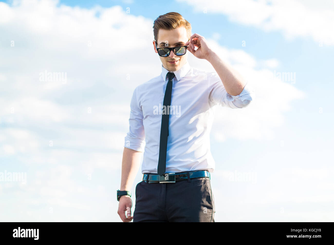 Grave busunessman giovani in camicia bianca e cravatta e occhiali da sole  sta Foto stock - Alamy
