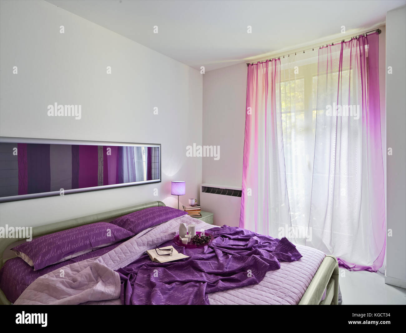 Vista interna di una camera da letto moderno con copriletto di colore viola Foto Stock