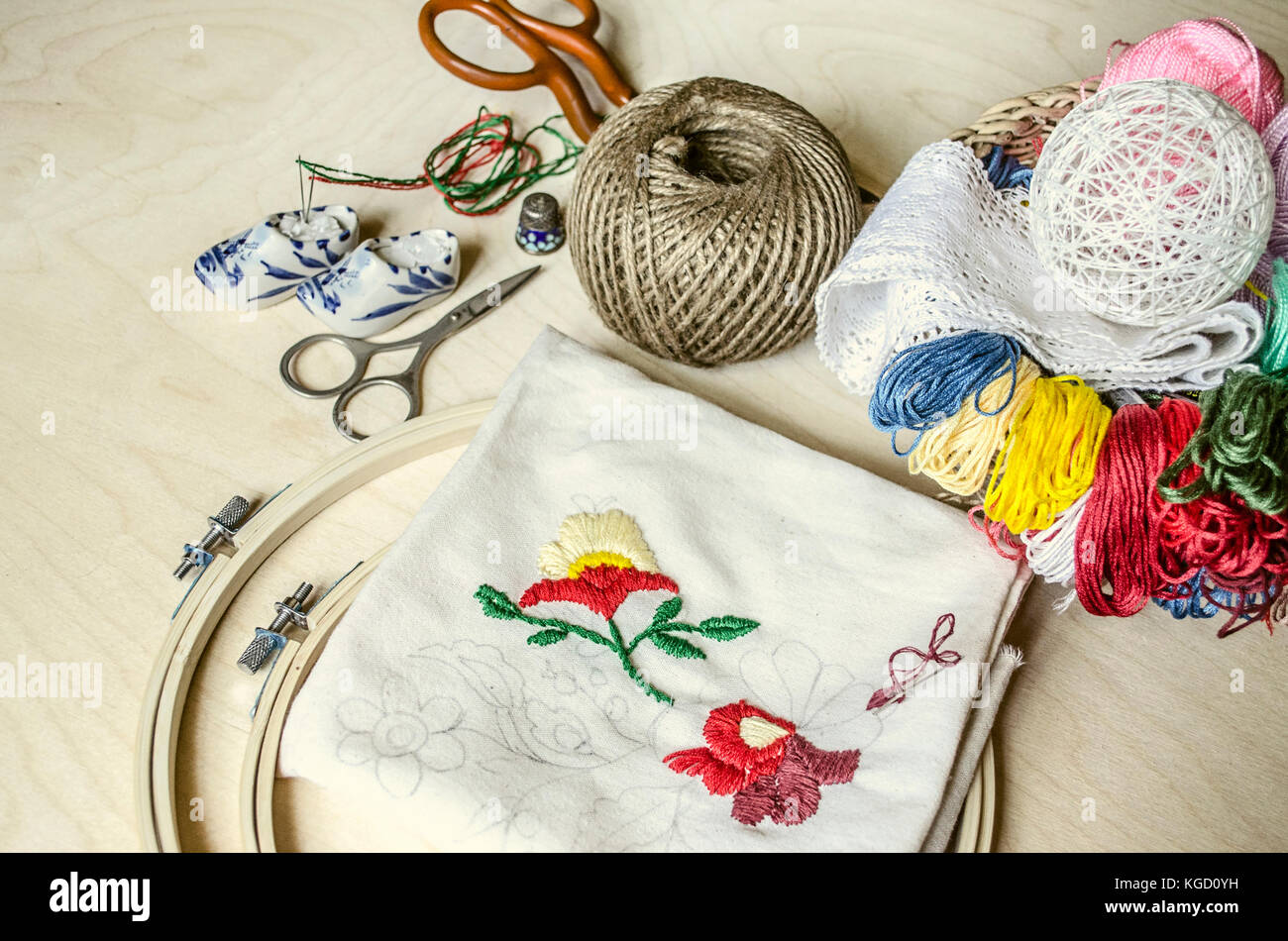 Filo colorato, aghi, forbici e telaio gli strumenti necessari per ricami Foto Stock