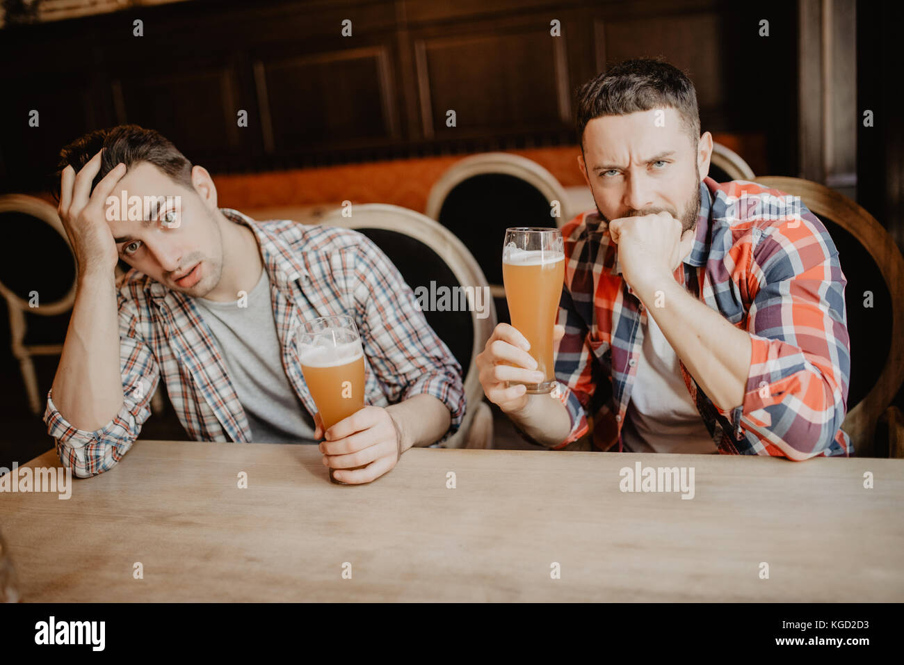 Giovane uomo barbuto cercando sconvolto e triste avente la birra al pub copyspace depressione stress stanco Foto Stock