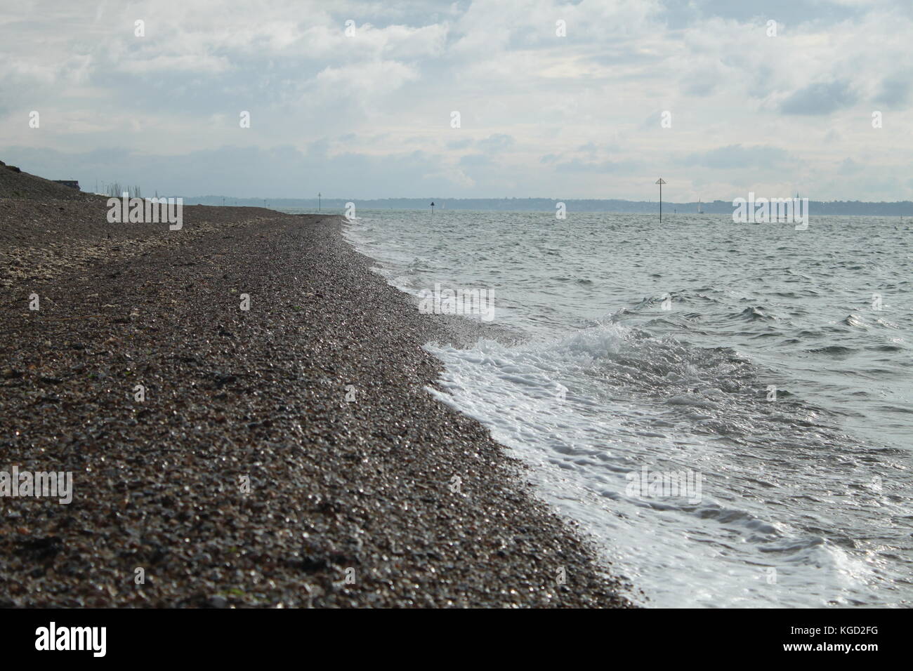 Onde che si infrangono sulla spiaggia di ghiaia Foto Stock