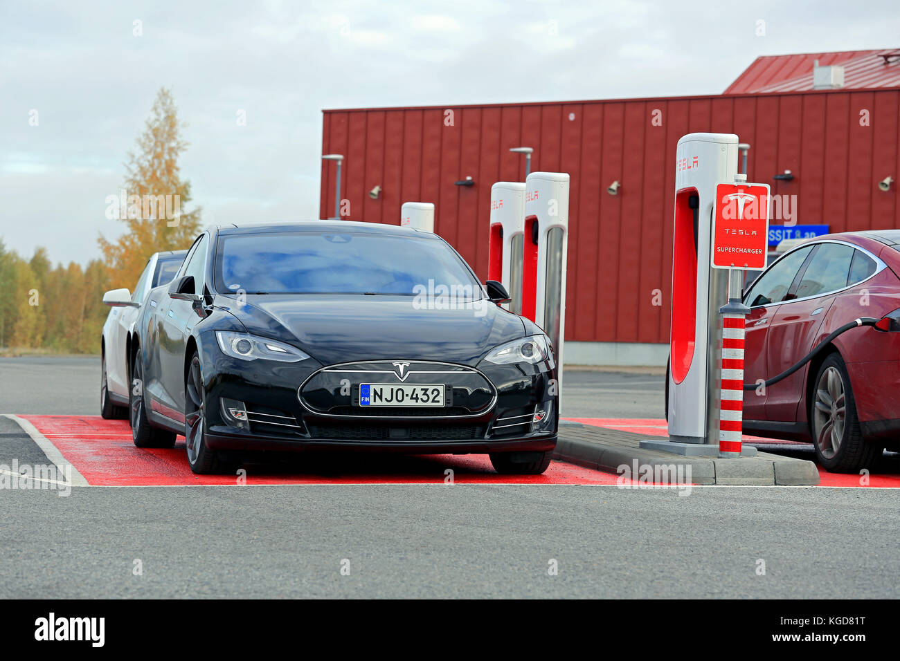 TOIJALA, Finlandia - 17 ottobre 2015: Tre Tesla Model S vetture vengono caricate in Tesla Supercharger stazione. Attualmente ci sono due Tesla Superchar Foto Stock