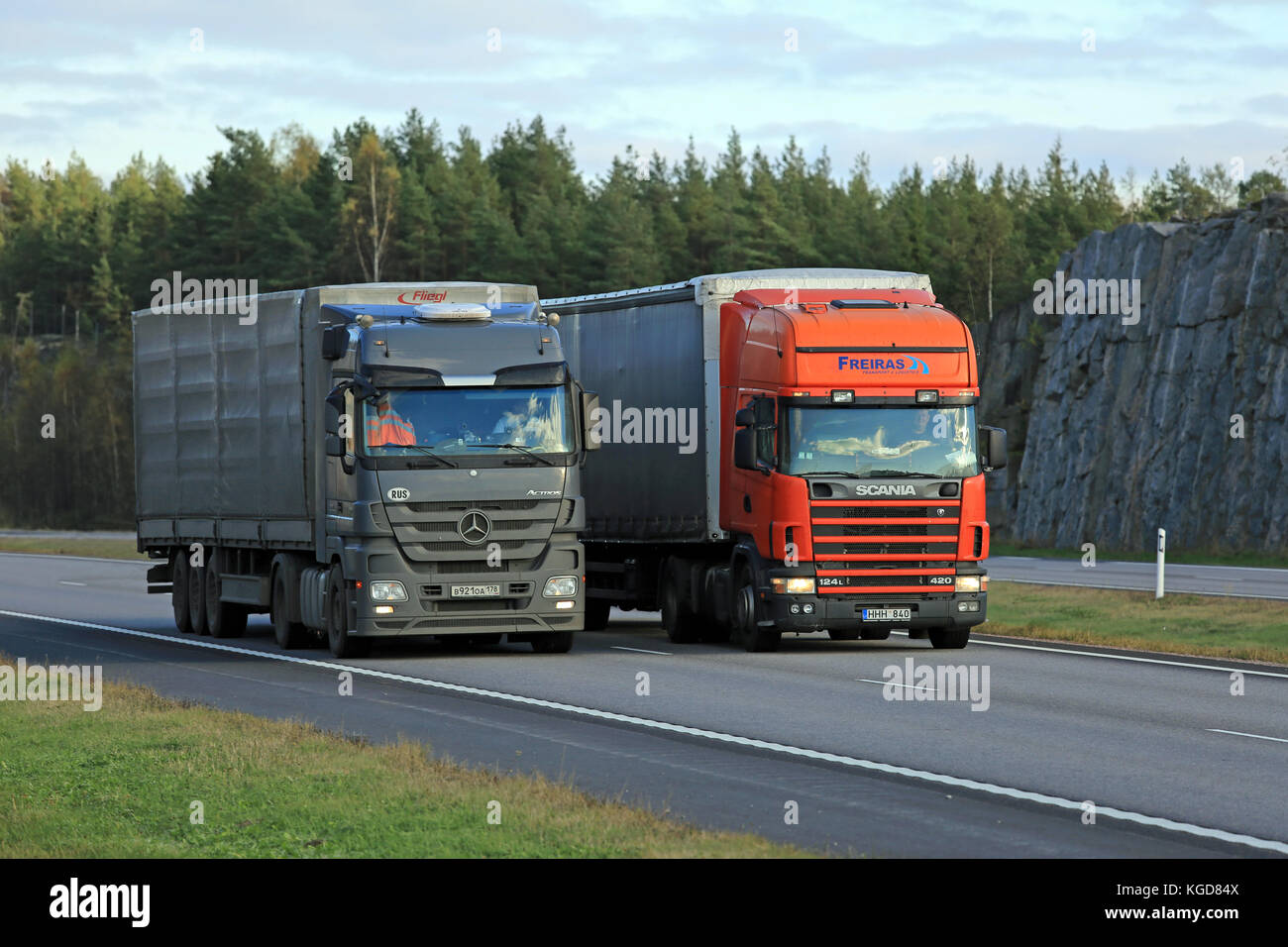 Paimio, Finlandia - 16 ottobre 2015: scania 124l semi supera un altro carrello su autostrada. carrelli elevatori con carico pesante possono essere molto più lento in salita. Foto Stock