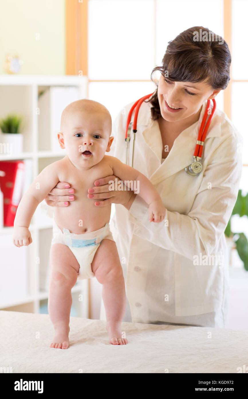 Medicina, sanità e pediatria concetto. Felice medico o il pediatra e il bambino gioca su esame medico presso la clinica Foto Stock