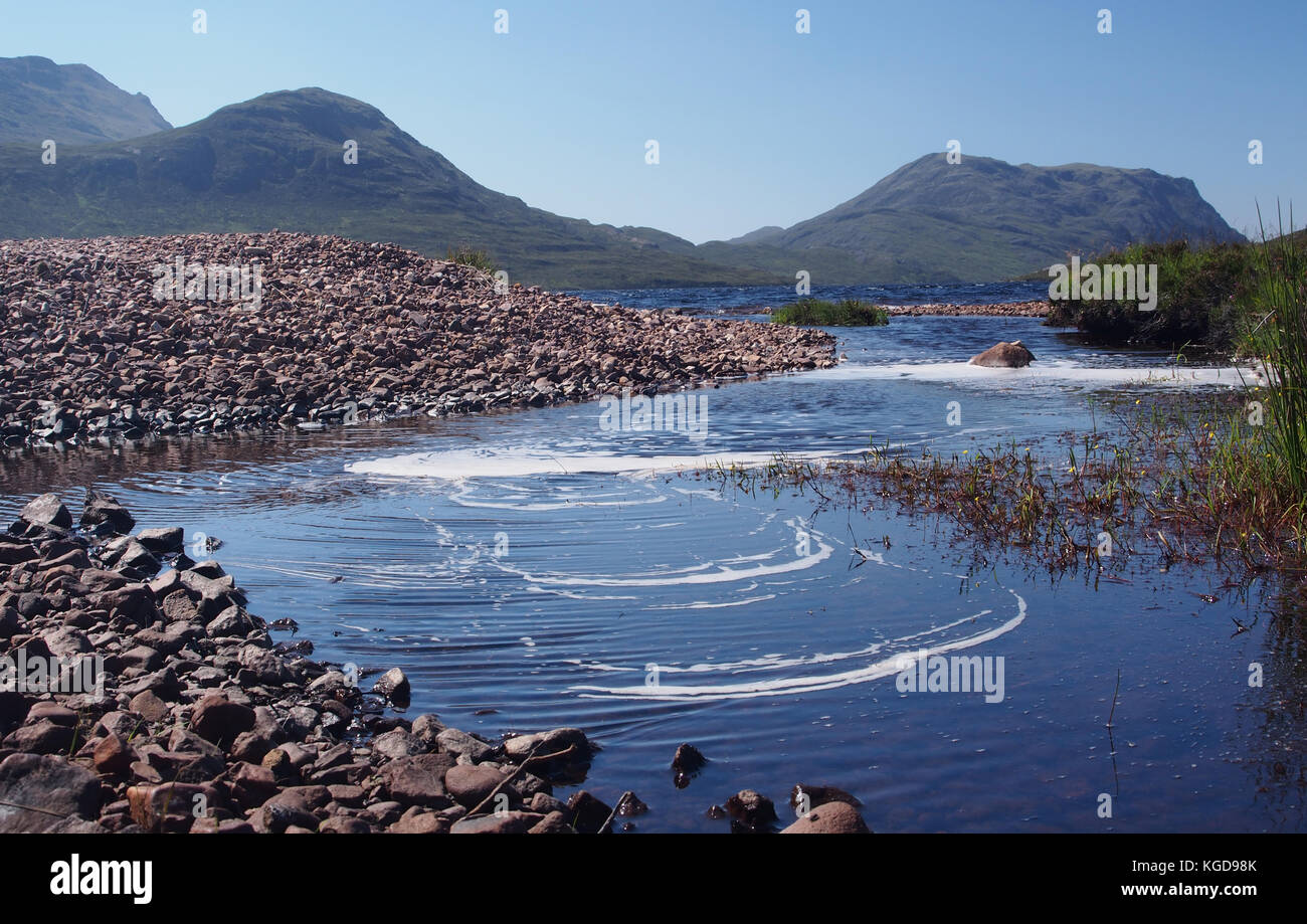 Vorticoso dell'acqua in corrispondenza del bordo del Loch Fada, Scozia Foto Stock