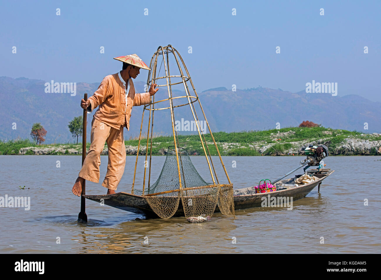 Pescatore intha sterzo tradizionale barca da pesca avvolgendo la sua gamba intorno il remo, Lago Inle, nyaungshwe, stato shan, myanmar / BIRMANIA Foto Stock