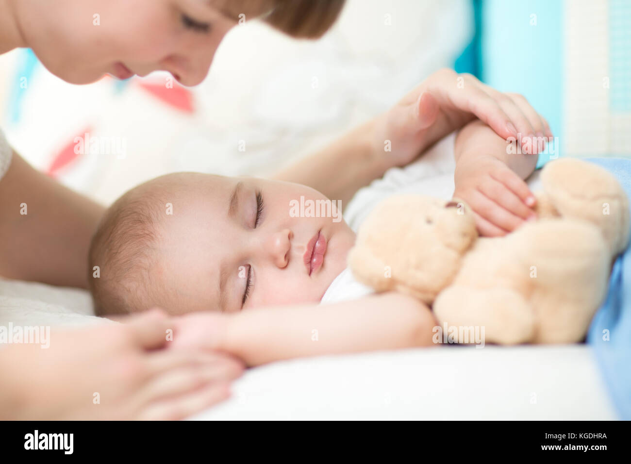 Maternità paternità. giovane madre guardando il suo bambino dorme nel letto Foto Stock